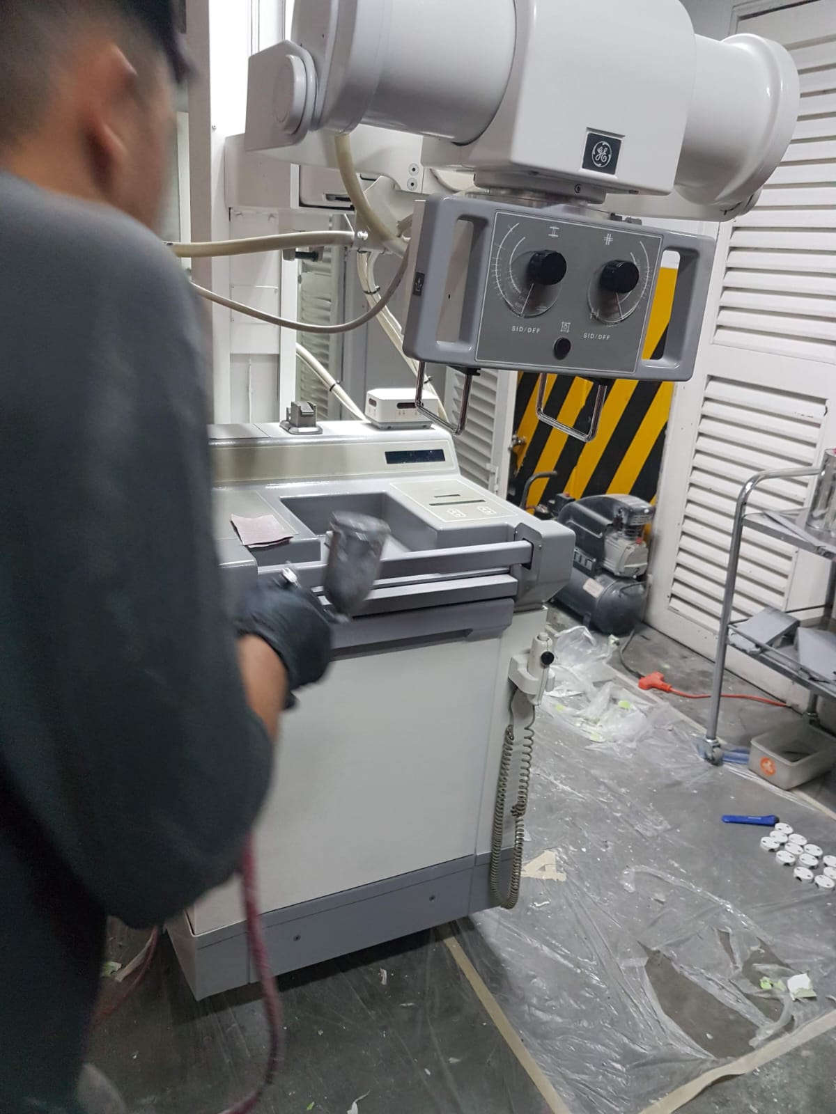 Técnico realizando mantenimiento correctivo a equipo de rayos X General Electric con intervención en sistema de alimentación eléctrica